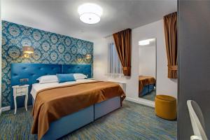 a bedroom with a large bed and a blue headboard at Hotel Skradinski Buk in Skradin