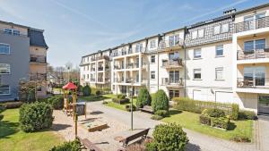 budynek apartamentowy z placem zabaw przed nim w obiekcie Dom & House - Apartments Parkur Sopot w mieście Sopot