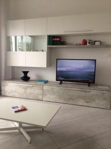 ein Wohnzimmer mit einem Flachbild-TV an der Wand in der Unterkunft Appartamento sul porto in Loano