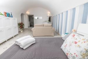 um quarto com uma cama, um sofá e uma cadeira em To Be Capri em Capri