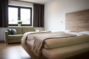 a bedroom with two beds and a couch and a window at Flussbett in Kirchberg an der Pielach