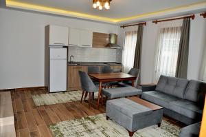 a kitchen and a living room with a couch and a table at Etap Uzungöl Suite Hotel in Uzungöl