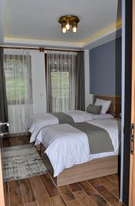 a bedroom with three beds and a window at Etap Uzungöl Suite Hotel in Uzungöl