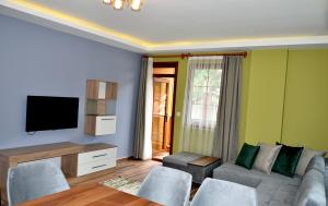a living room with a couch and a flat screen tv at Etap Uzungöl Suite Hotel in Uzungöl