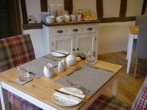 a table with plates and glasses on top of it at Grove Barn Bed and Breakfast in Harleston