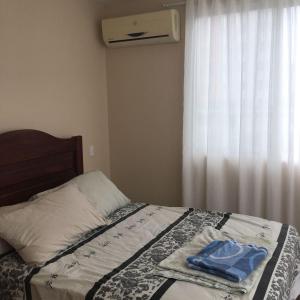 a bedroom with a bed with a pillow and a window at Departamento playa Tonsupa, Esmeraldas in Tonsupa