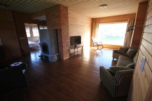 a living room with a fireplace and a tv at Ranna puhkemaja in Lemsi