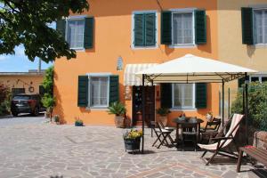 pomarańczowy budynek ze stołem i parasolem w obiekcie Bed & Breakfast Lucca Fora w mieście Capannori