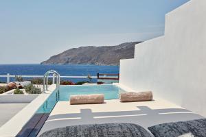 a bedroom with a pool and a view of the ocean at Archipelagos Hotel - Small Luxury Hotels of the World in Kalo Livadi