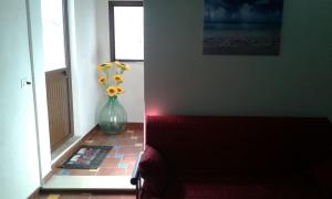 a vase with flowers on a floor in a hallway at Pettinato in Portopalo