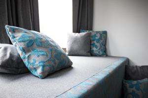 um sofá azul com almofadas ao lado de uma janela em Flussbett em Kirchberg an der Pielach mais 3 fotografias
