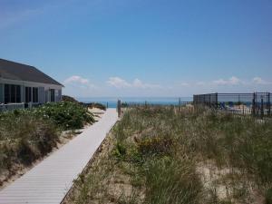 a path to the beach with a house and the ocean at Horizons Beach Resort in North Truro