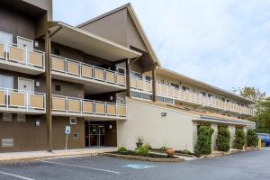 an apartment building with balconies and a parking lot at Days Inn by Wyndham Harrisburg North in Harrisburg