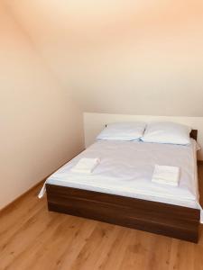 レバルにあるApartamenty Letnie BALTIC VIPのベッド(白いシーツ、白い枕付)