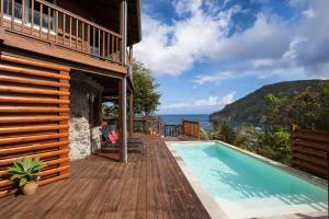 una casa con piscina en una terraza en Palm Bay, en Deshaies