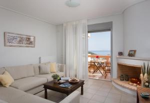 a white living room with a couch and a table at Comfortable house with amazing view in Anavyssos