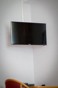 telewizor z płaskim ekranem wiszący na ścianie w obiekcie Hotel Alscher w mieście Leverkusen