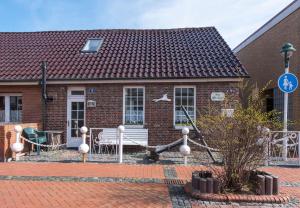una casa in mattoni con un parco giochi di fronte di Haus Alte Kiefer Whg 2 a Norderney