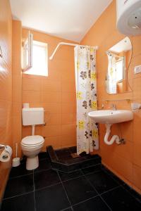 a bathroom with a toilet and a sink at Apartments Victoria in Sutomore