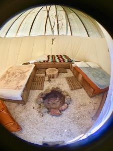 an inside of a dome with two beds and a fireplace at Les Tipis du Bonheur de Vivre in Brûlon