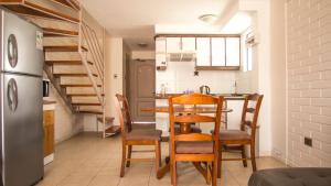cocina con mesa, sillas y nevera en TerraBahia Residences en Bahía Inglesa