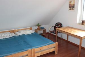 1 dormitorio con cama, mesa y escritorio en Dom nad jeziorem, en Świętajno