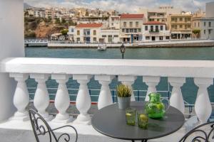 a table on a balcony with a view of the water at Porto Maltese Boutique Estate in Agios Nikolaos