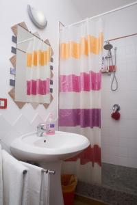 baño con lavabo y cortina de ducha en La Torretta, en Tuscania