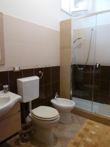 a bathroom with a toilet and a sink and a shower at Sole in San Vito lo Capo