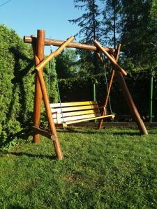 a wooden swing set in a park with a yard at Domek u Piotra koło Szczyrku in Kalna