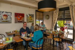 a group of people sitting at tables in a restaurant at De Herberg in Renesse