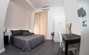 1 dormitorio con cama, mesa y escritorio en B&B Diana, en Piazza Armerina
