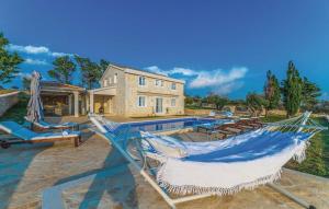 a hammock on a patio next to a pool at Villa Toma I in Novalja