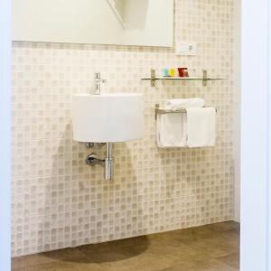 baño con lavabo y pared de azulejos en Rio Sil Carballo, en Carballo