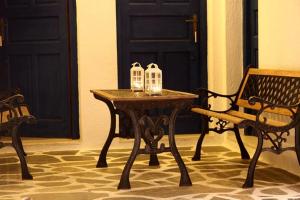 a wooden table with two candles on it next to a bench at Angelos Rooms in Irakleia