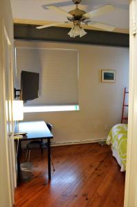 a room with a desk with a computer and a ceiling fan at Modern B & B in Houston
