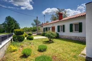 a house with a yard with grass and bushes at Villa Angelina in Pićan