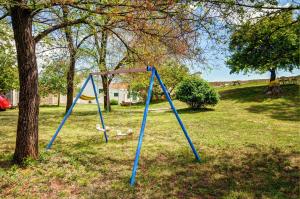 a swing set in a field next to a tree at Villa Angelina in Pićan