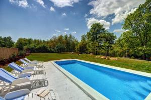 a swimming pool with lounge chairs next to a yard at Villa Angelina in Pićan
