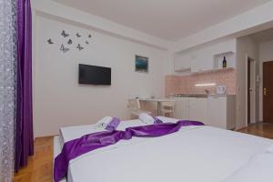 a bedroom with a large bed and a kitchen at Protuger in Ohrid