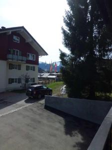 une voiture garée dans un parking à côté d'un bâtiment dans l'établissement kloi und scheee, à Oberstaufen