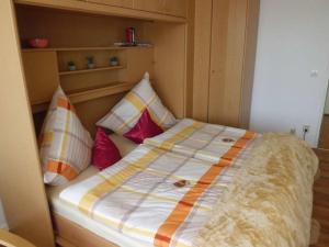 a bed with pillows on it in a room at kloi und scheee in Oberstaufen