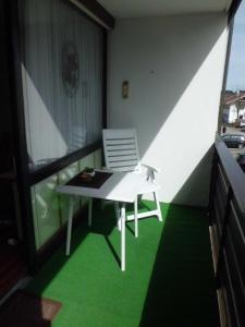 d'un balcon avec une table blanche et une chaise. dans l'établissement kloi und scheee, à Oberstaufen