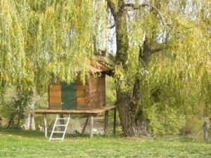 une cabane dans les arbres assise sur un support à côté d'un arbre dans l'établissement Les Convertigues, à Montjoire