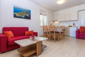 a living room with a red couch and a table at Apartments Medini in Veli Rat