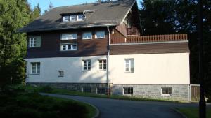 ein großes weißes Haus mit Holzdach in der Unterkunft Zollhaus in Bad Elster