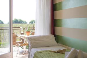 a bedroom with a bed and a balcony with a table at The Lighthouse Rooms in Lazise