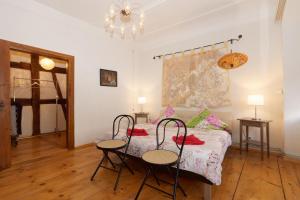 a bedroom with a bed with two chairs and two tables at Klosterherberge in Meßkirch