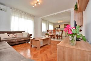 una sala de estar con un jarrón de flores sobre una mesa en Apartment Lovre, en Kaštela