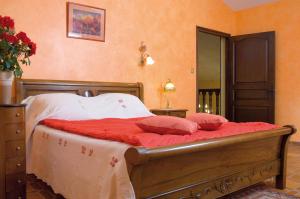 a bedroom with a bed with red pillows on it at Les Loges du Jardin d'Aymeric in Clara